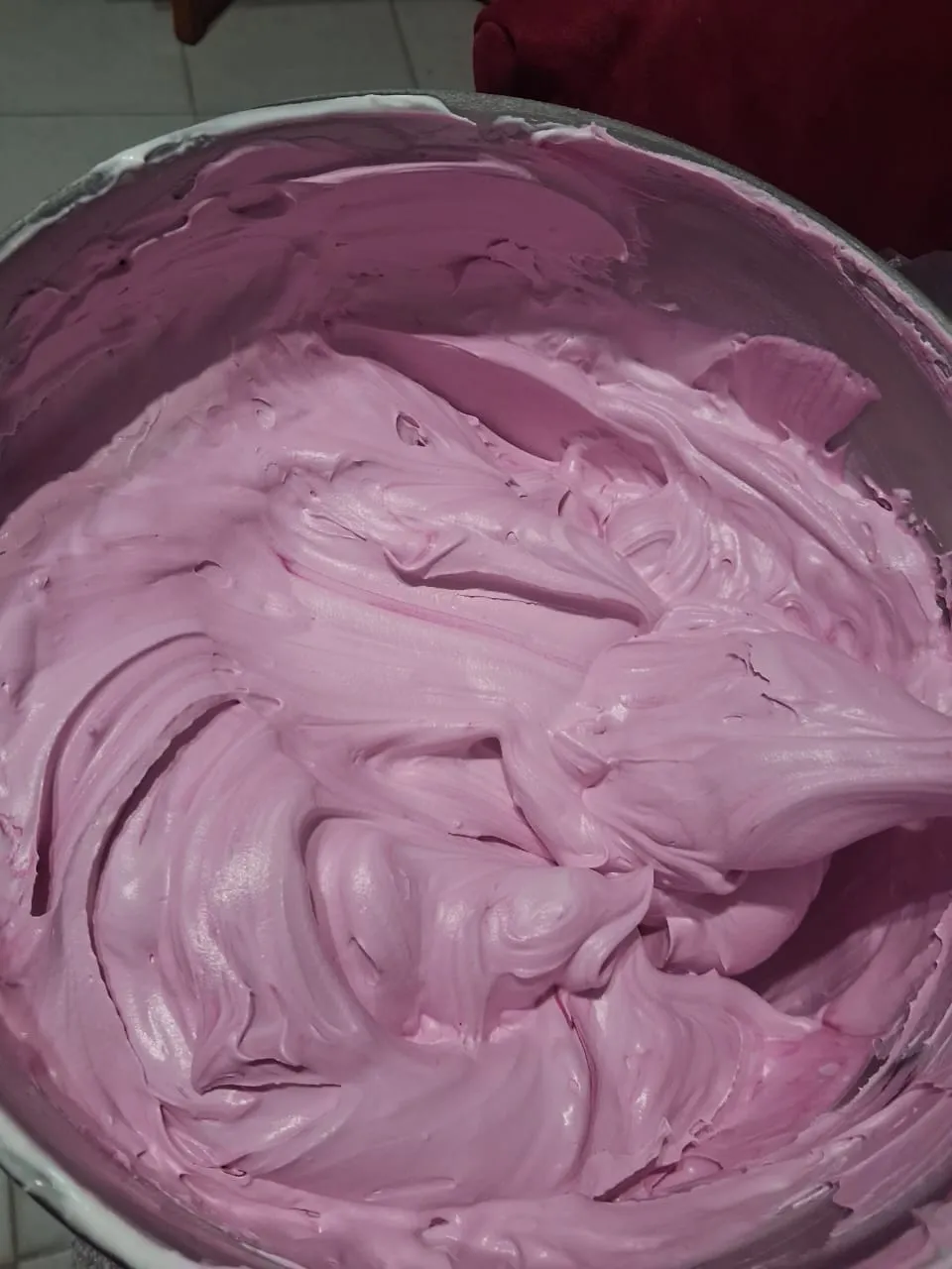 Decoración manual de torta rosada con crema pastelera en Caracas