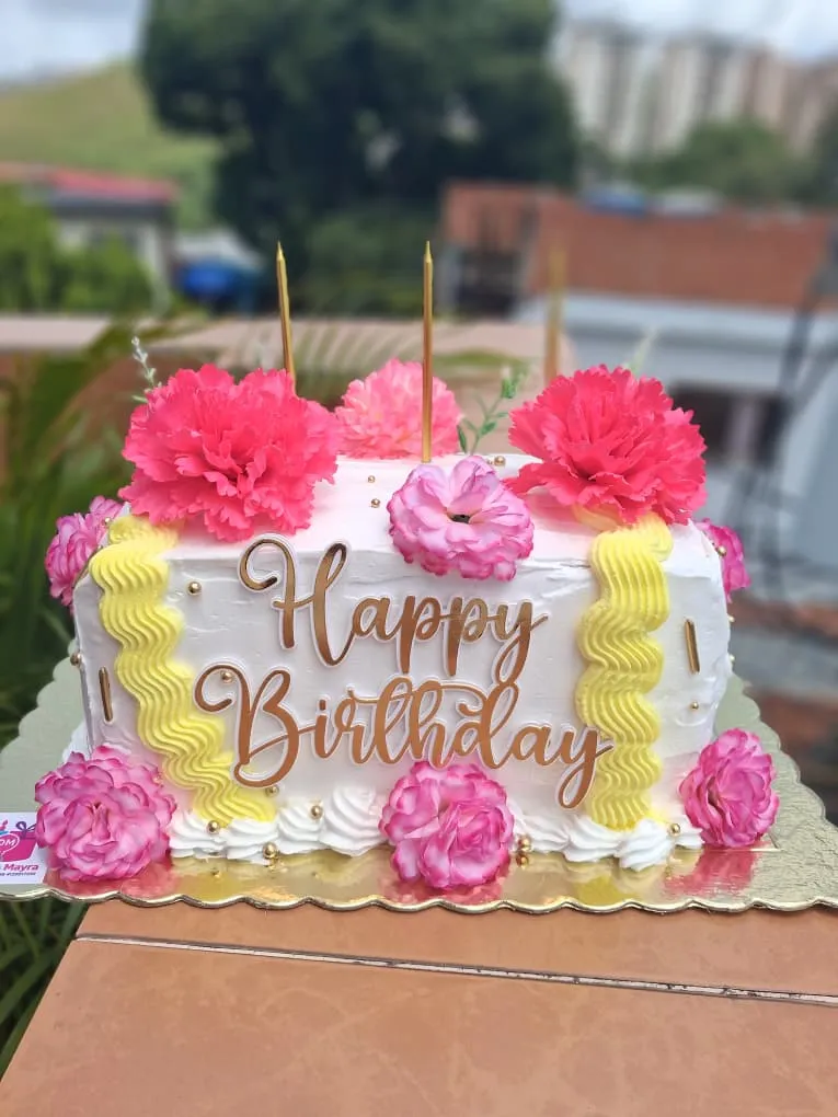 Torta blanca de 30 años decorada con crema chantillí, flores rojas decorativas y letras grandes de Happy Birthday, rellena de fresas con crema