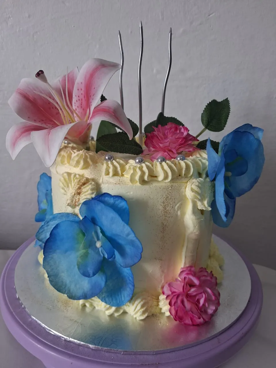 Torta amarilla decorada con flores artificiales para cumpleaños en Caracas